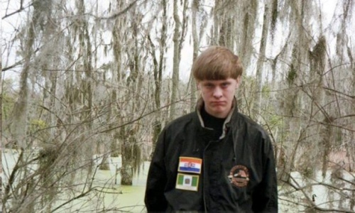Dylann Roof. On his jacket are the flags of apartheid South Africa and colonial Rhodesia (Zimbabwe under white rule).